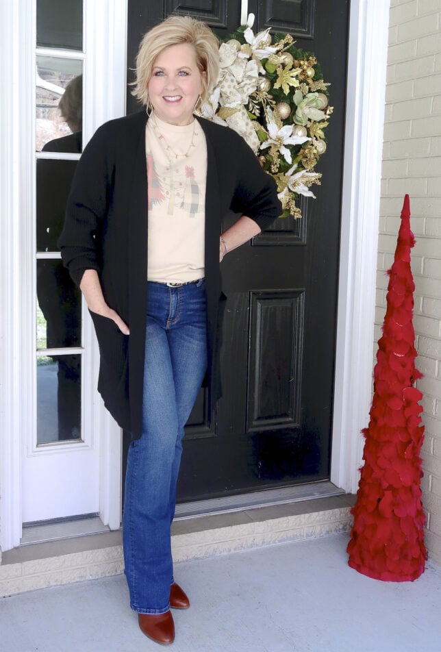 Fashion Blogger 50 Is Not Old looks long and lean in flare jeans and a black cardigan
