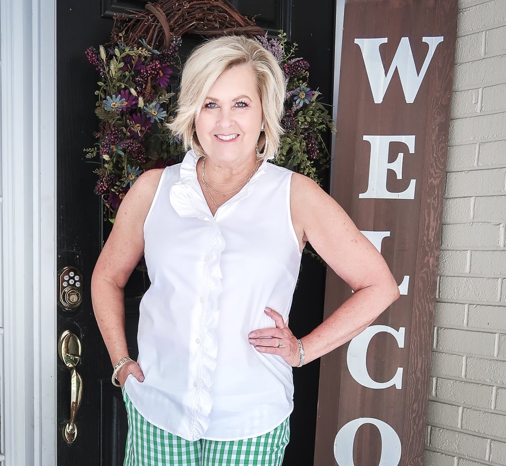 FASHION BLOGGER 50 Is Not Old wearing a sleeveless top with a ruffled neckline