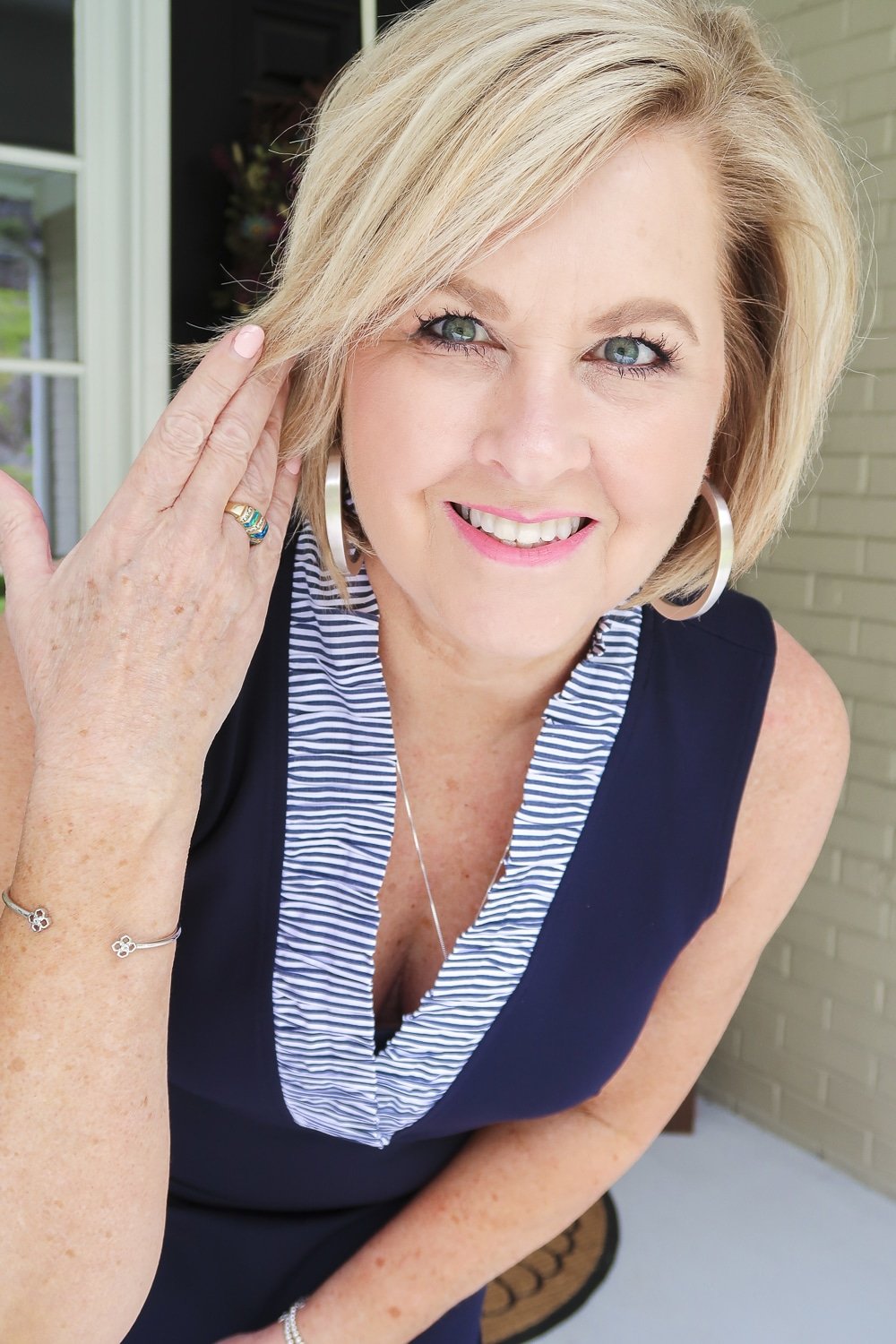 Fashion Blogger 50 Is Not Old is celebrating turning 60 with a navy sheath dress with a striped ruffled neckline and silver jewelry from Kendra Scott