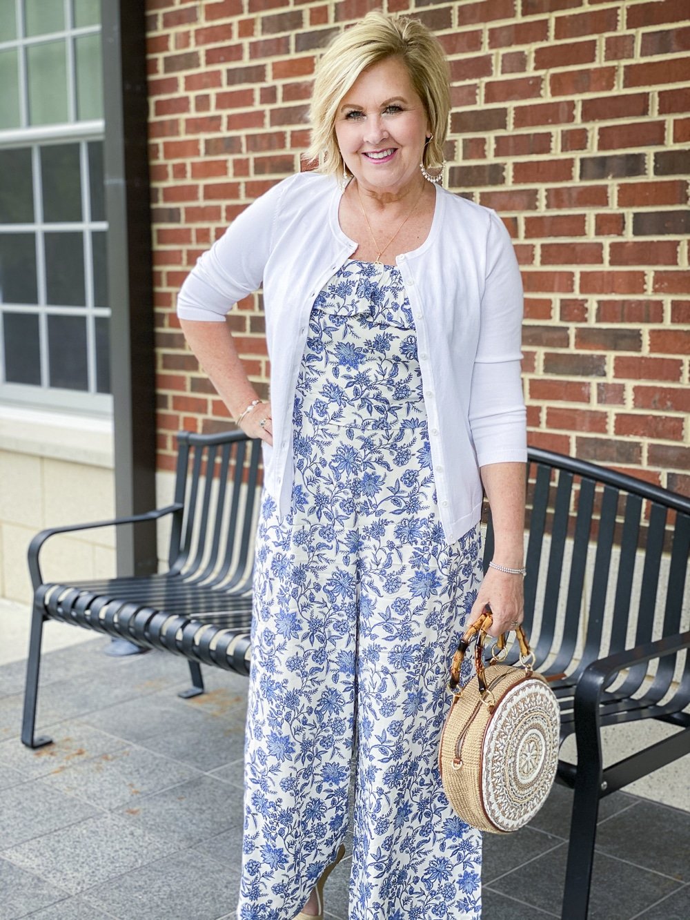 Fashion Blogger 50 Is Not Old is wearing a blue and white jumpsuit and a white cardigan sweater
