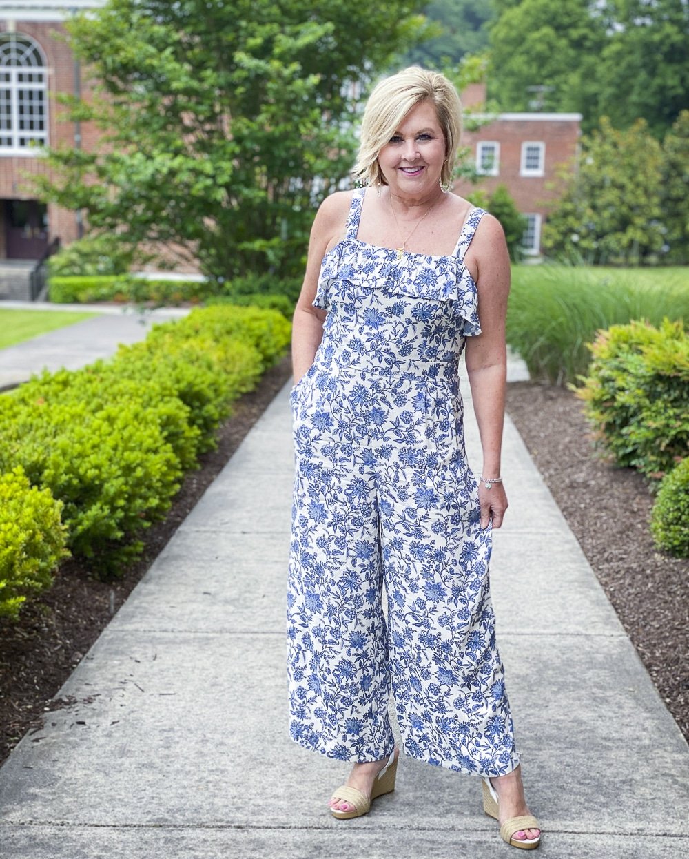 Fashion Blogger 50 Is Not Old is wearing a blue and white jumpsuit from Loft with espadrille wedge sandals