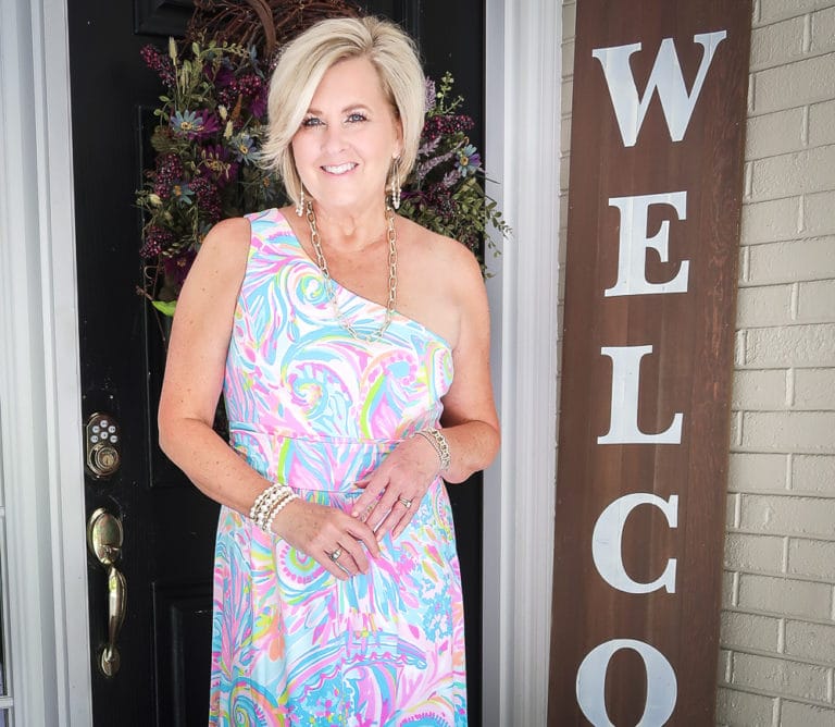 Fashion Blogger 50 Is Not Old is styling a one shoulder Lilly Pulitzer maxi dress with jewelry from Kendra Scott