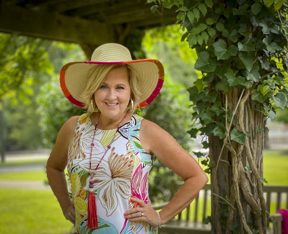 Fashion Blogger 50 Is Not Old is wearing a tropical print sleeveless dress with a straw hat