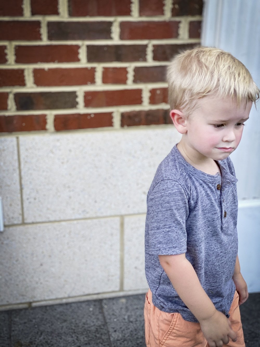 Fashion Blogger 50 Is Not Old's grandchildren in their back to school outfits. He is wearing a gray henley tee shirt while looking away
