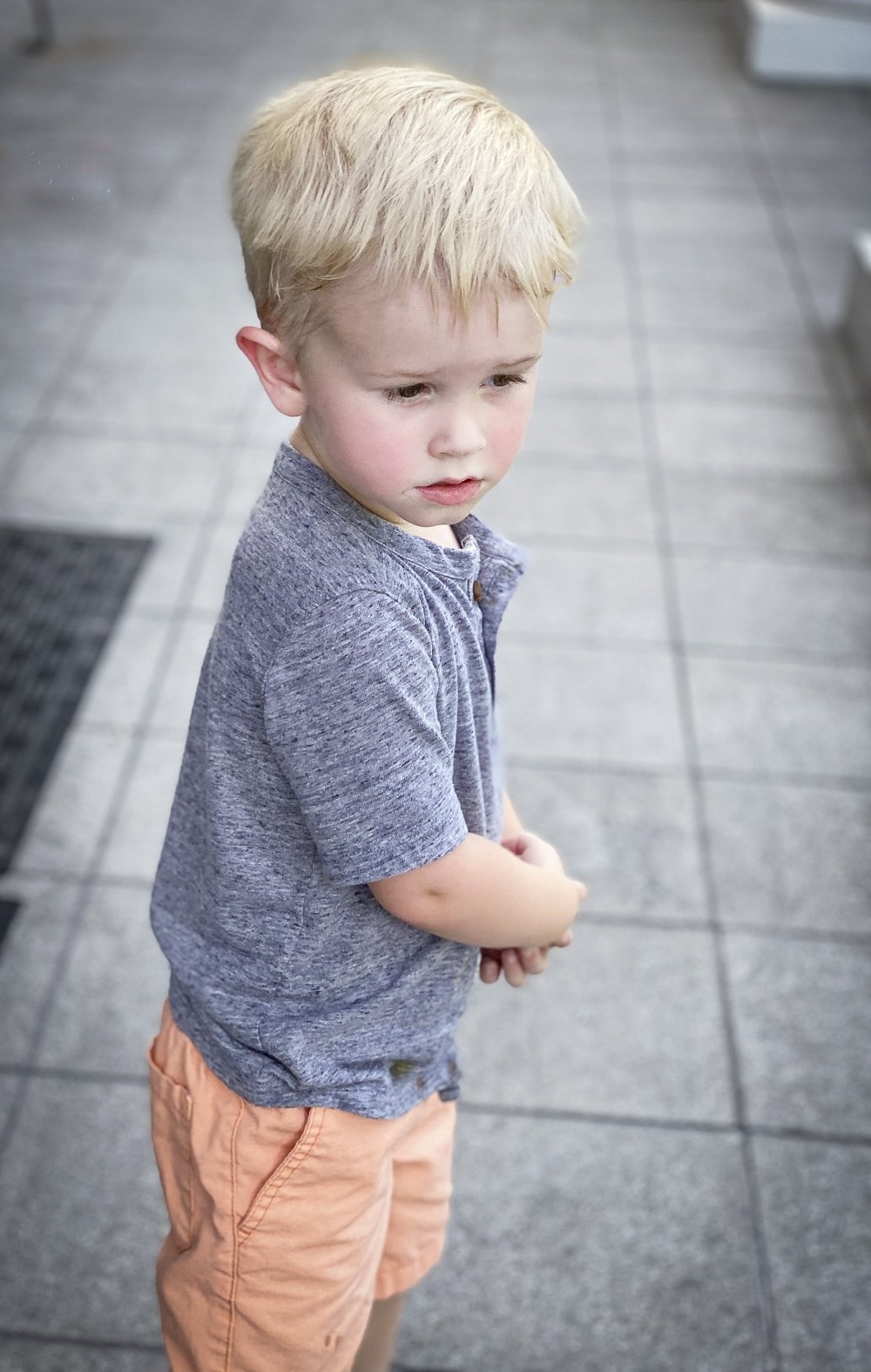 Fashion Blogger 50 Is Not Old's grandchildren in their back to school outfits. He is wearing a gray henley tee shirt, orange shorts from Carters