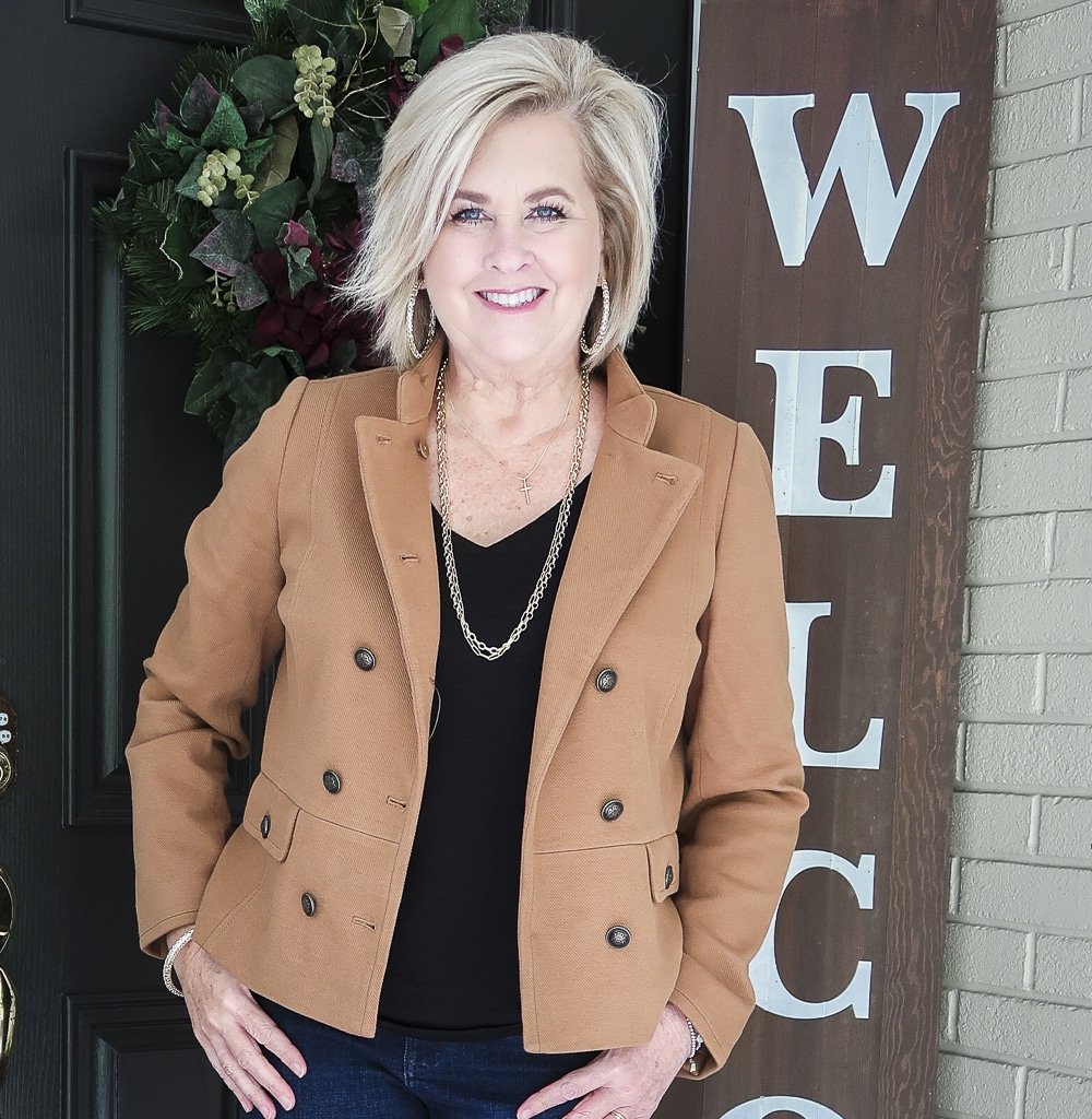 Fashion Blogger 50 Is Not Old is wearing a Camel jacket, and a black v-neck top