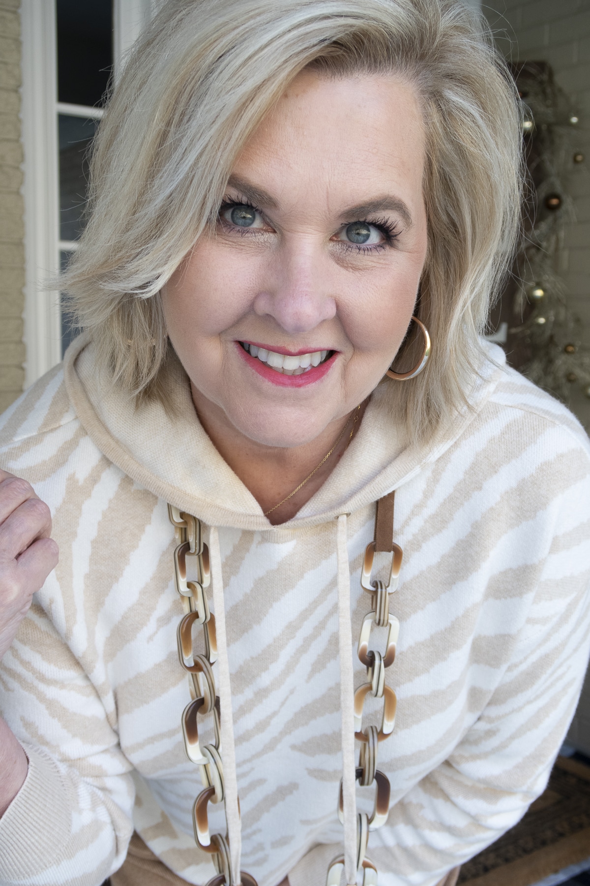 Fashion Blogger 50 Is Not Old is showing the material on a Tiger-Print cashmere-blend hoodie and camel joggers