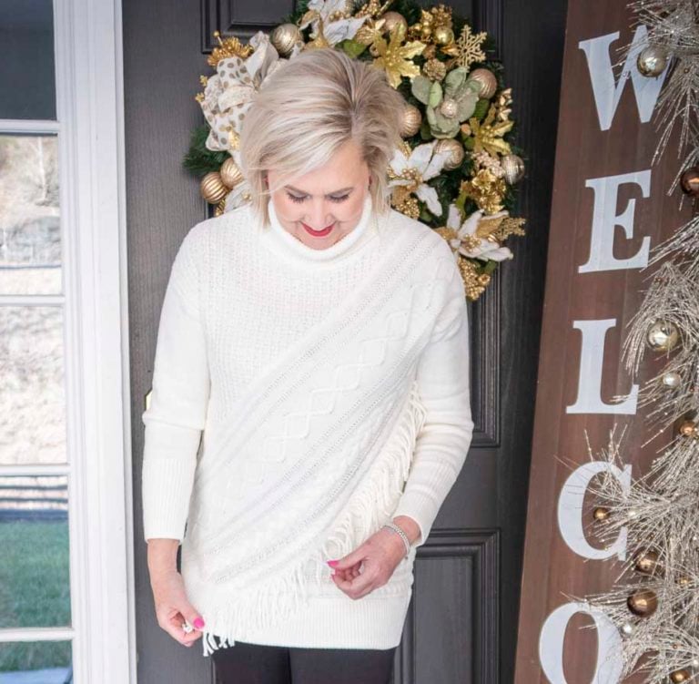 Fashion Blogger 50 Is Not Old is styling a Ecru sweater with unique details including fringe