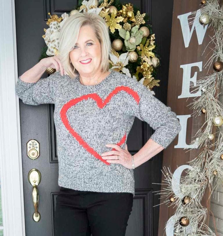 Fashion Blogger 50 Is Not Old is wearing a black and white sweater with a large red heart