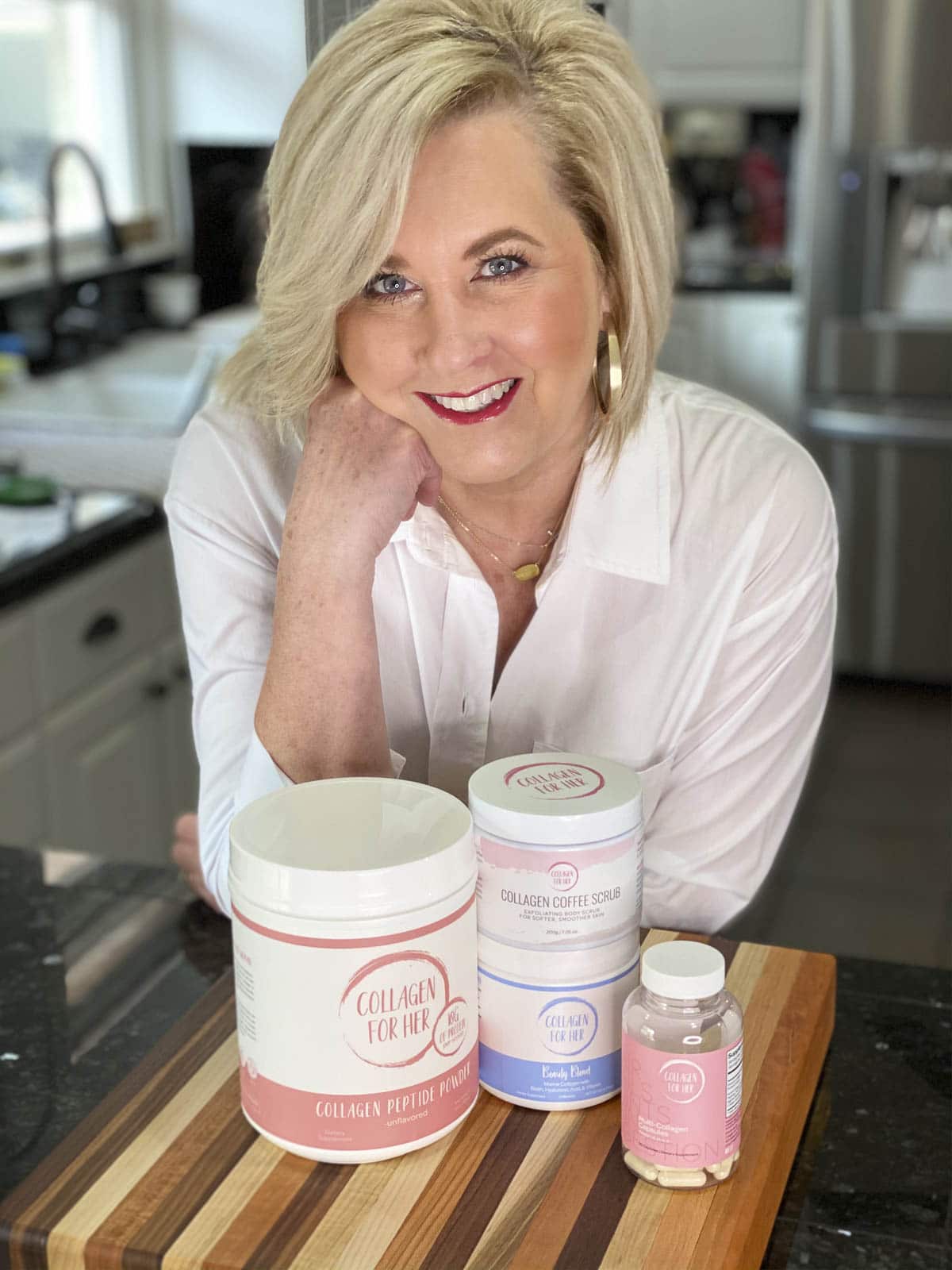 Fashion Blogger 50 Is Not Old is showing her Collagen For Her products in front of a cutting board