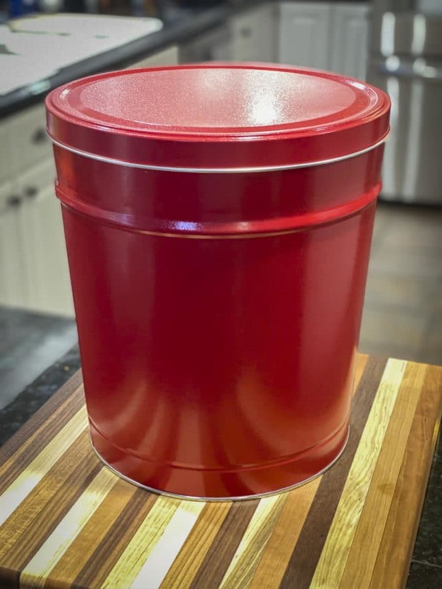 Fashion Blogger 50 Is Not Old is showing the huge red popcorn tin from the Popcorn Factory she purchased using her AARP member benefits