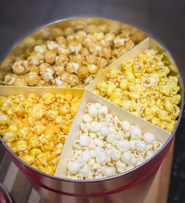 Fashion Blogger 50 Is Not Old is showing the four flavors of popcorn from the Popcorn Factory she purchased using her AARP member benefits