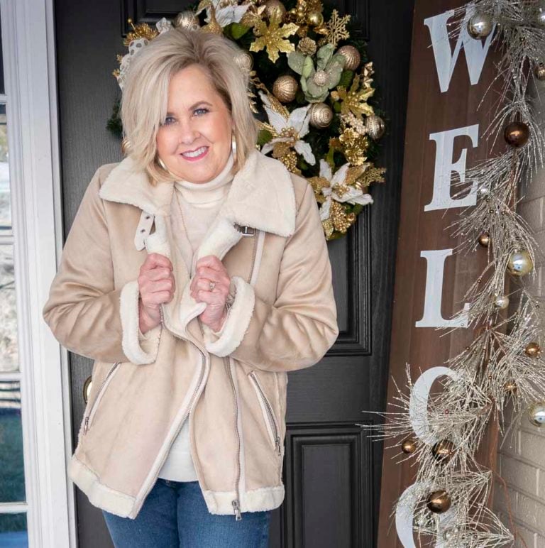 Fashion Blogger 50 Is Not Old is styling a sherpa moto jacket, an ivory turtleneck sweater