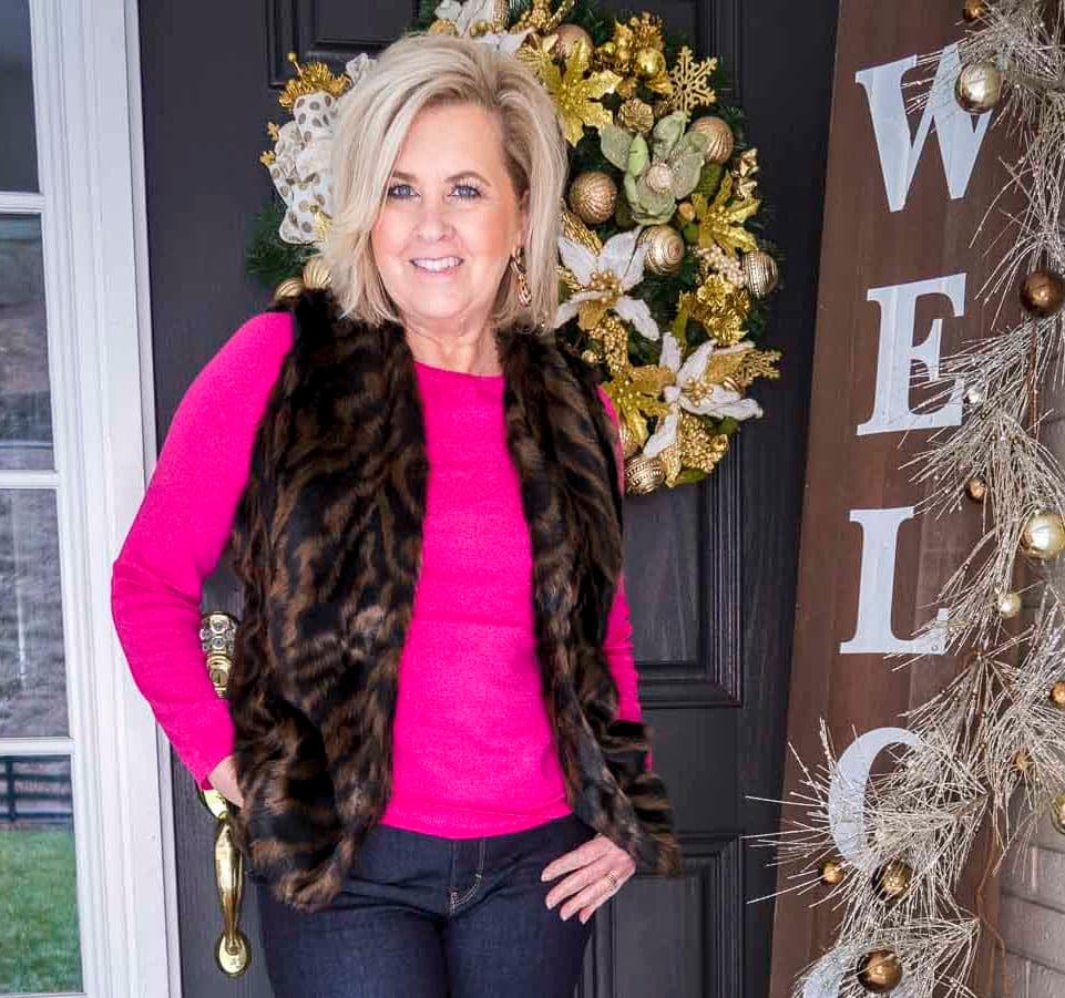 Over 40 Fashion Blogger 50 Is Not Old is wearing a bright color sweater with a tiger print faux fur vest