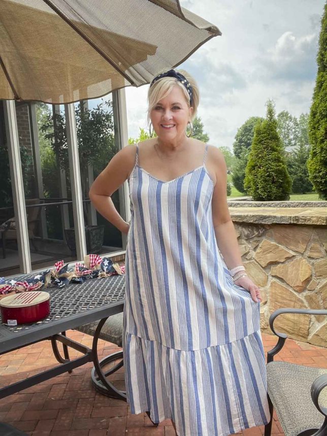 Fashion Blogger 50 Is Not Old is looking festive for the 4th of July in a blue and white striped sundress and a navy headband with stars