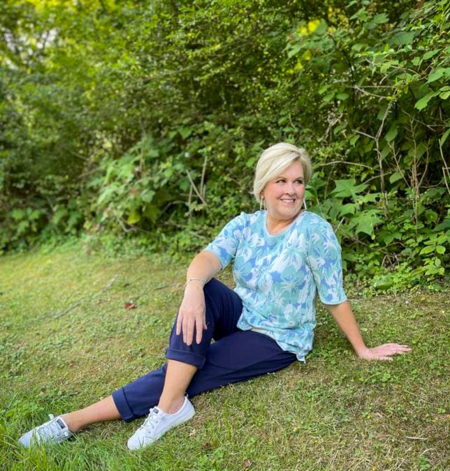Fashion Blogger 50 Is Not Old is comfortable looking in a floral sweater, navy pants, and white sneakers from Appleseeds