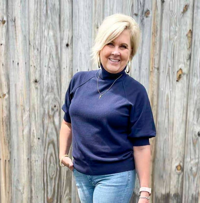 Over 40 Fashion Blogger, Tania Stephens, is wearing a navy puff sleeve turtleneck sweater 