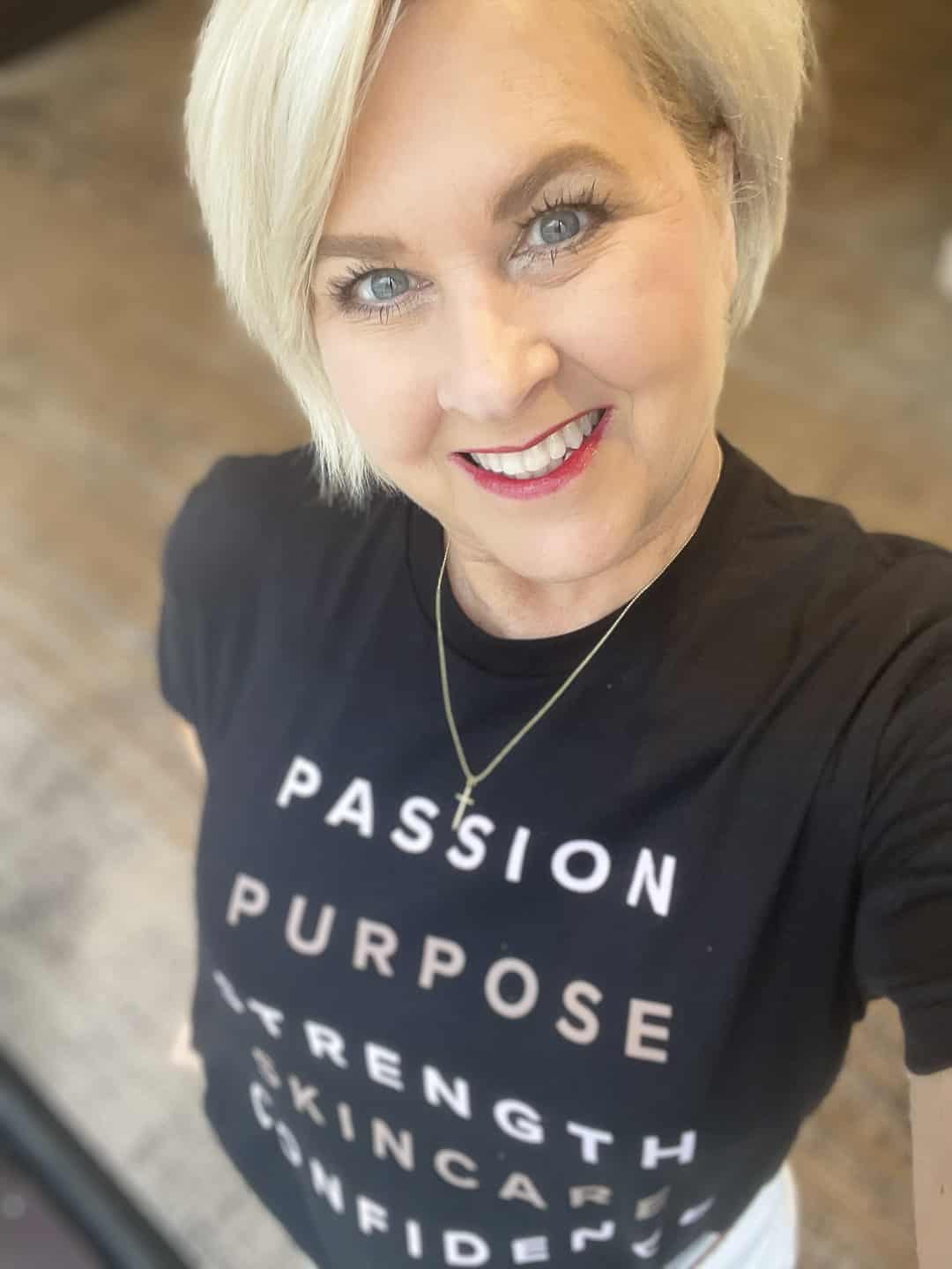 Over 40 Fashion Blogger, Tania Stephens, is wearing a black graphic tee from Rodan + Fields