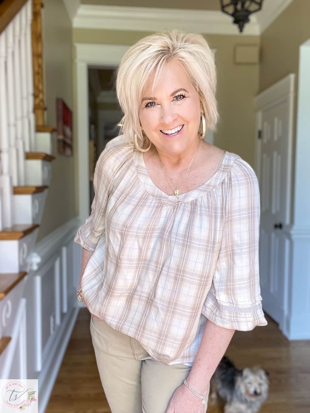 Over 40 fashion blogger, Tania Stephens, is wearing a cream plaid peasant top with gold jewelry