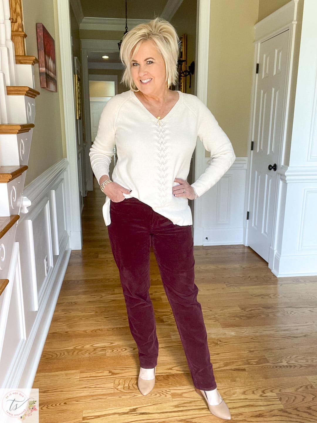 Over 40 fashion blogger, Tania Stephens, is wearing gold jewelry with deep plum corduroy straight-leg pants and a cream Pointelle sweater