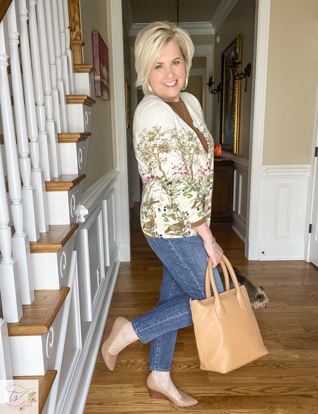 Over 40 Fashion Blogger, Tania Stephens is wearing a pheasant cardigan, girlfriend jeans, nude wedge pumps, and carrying a camel leather tote 