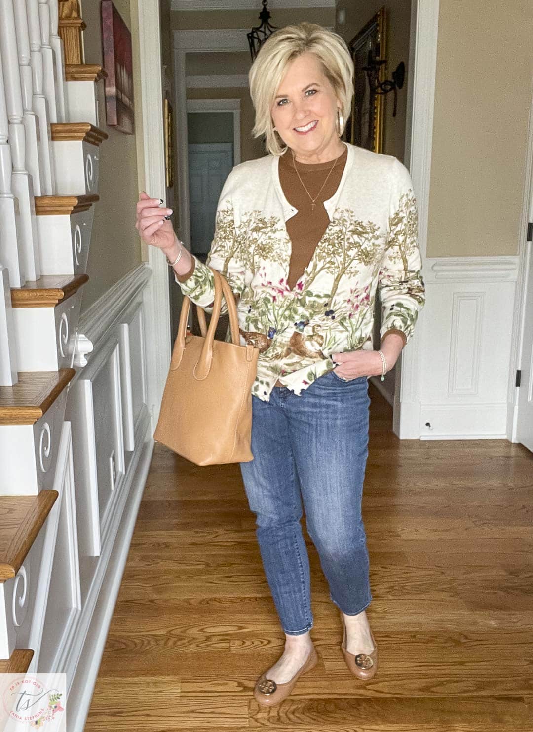 Over 40 Fashion Blogger, Tania Stephens is wearing a pheasant cardigan, girlfriend jeans, Tory Burch ballet flats, and carrying a camel leather tote that is perfect for Thanksgiving