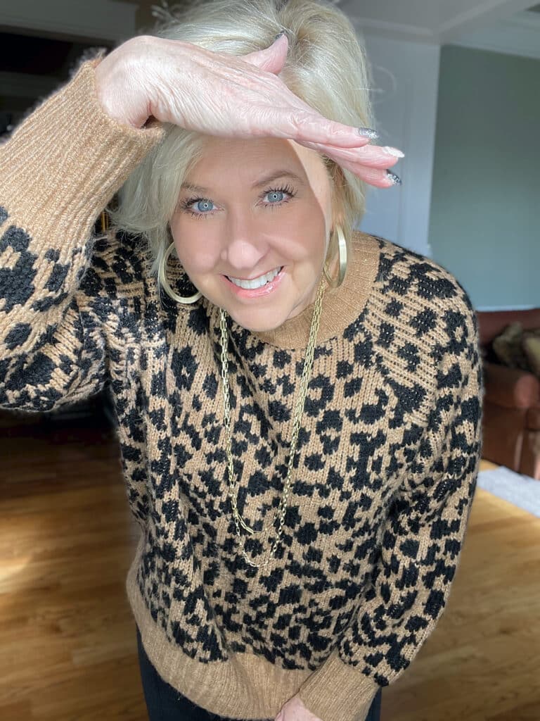 Over 40 Fashion Blogger, Tania Stephens is laughing in a leopard print sweater from Old Navy