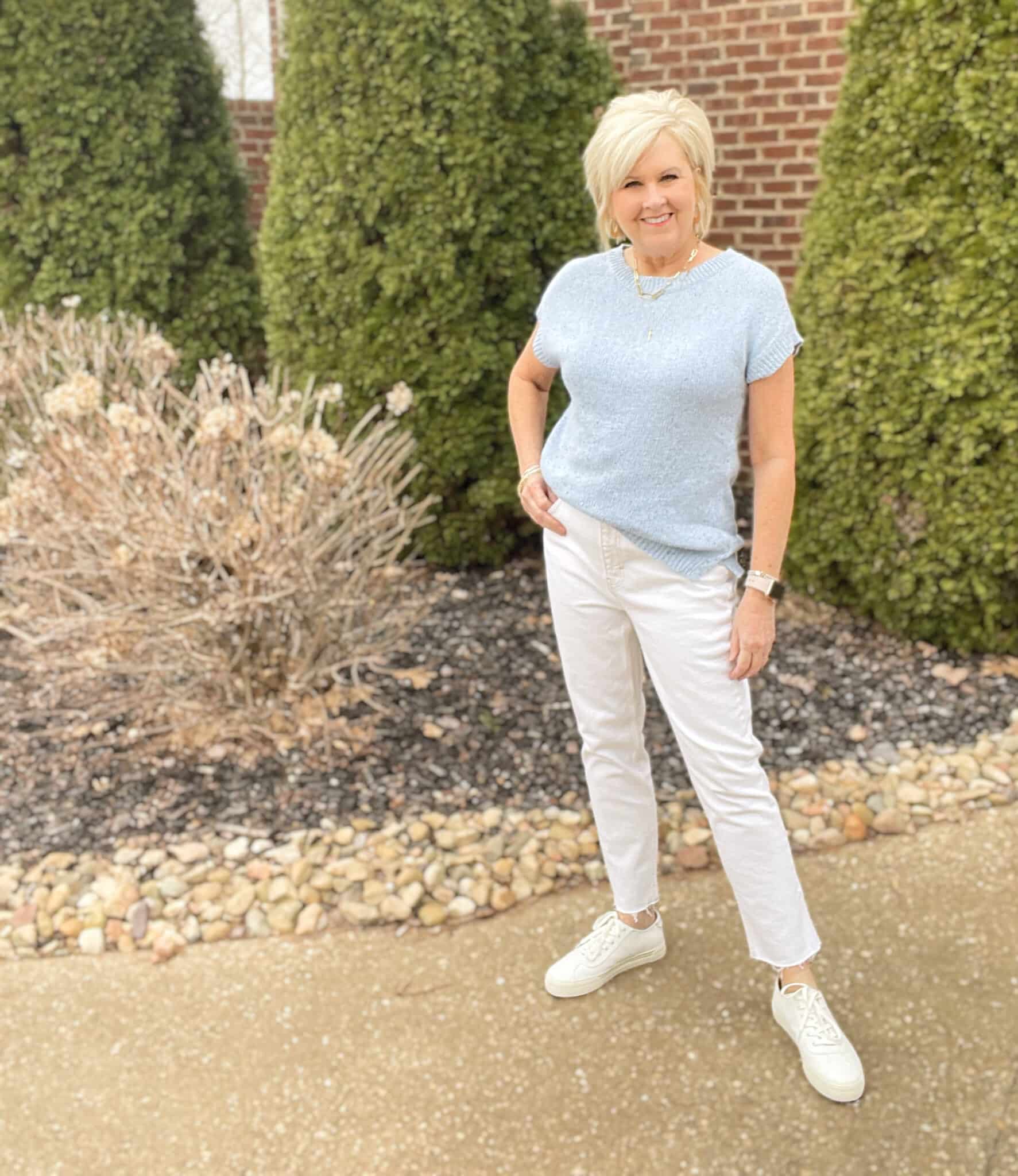 Over 40 Fashion Blogger, Tania Stephens is wearing a pale blue top and white raw hem jeans