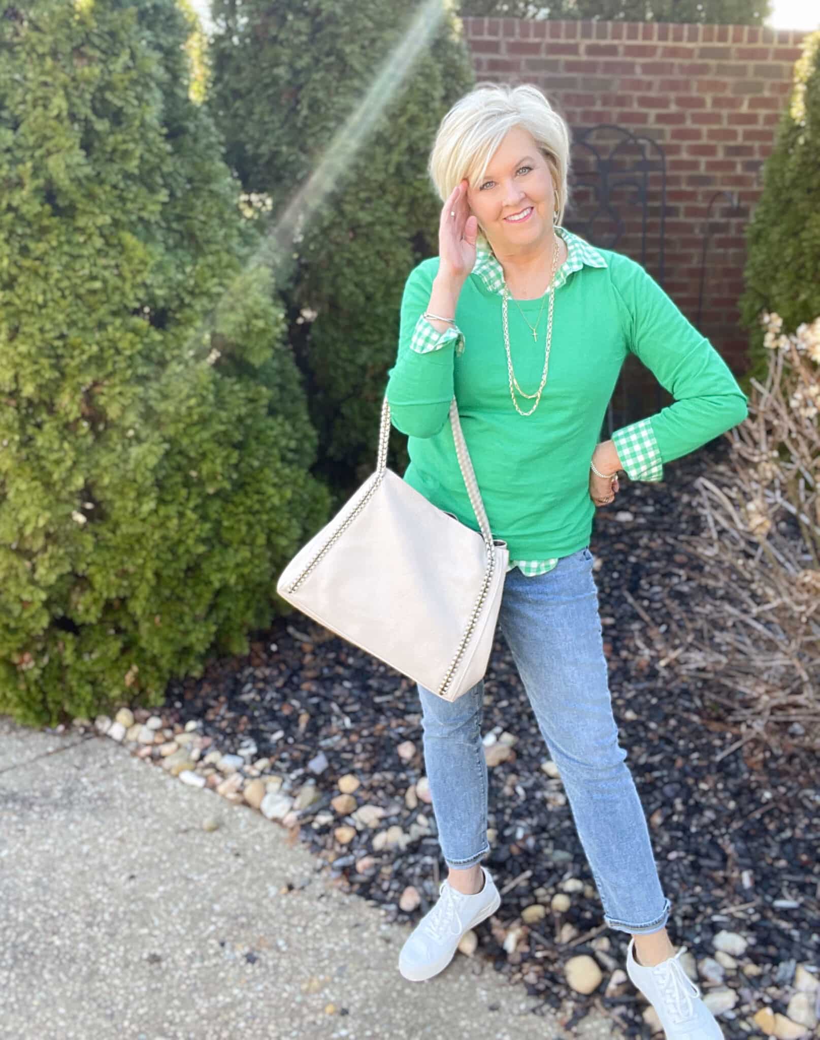 Over 40 Fashion Blogger, Tania Stephens is styling a green gingham shirt, a green sweater, jeans and white sneakers