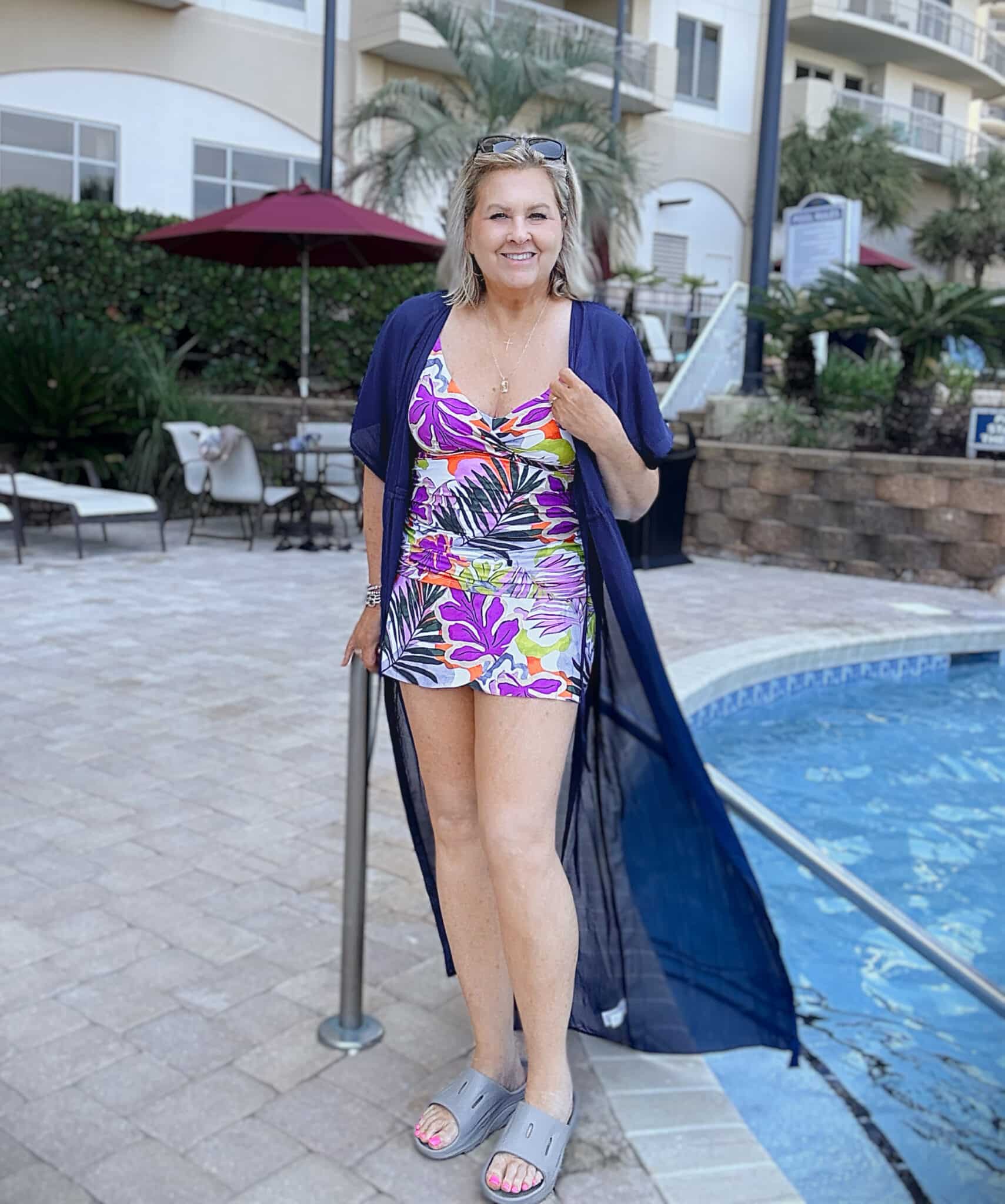 Tania wearing an Anne Cole Printed Underwired V-Neck Tankini top and swim skirt with a navy cover-up