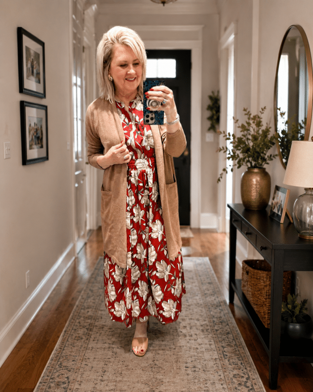 Tania standing in a hallway with a cardigan and printed dress