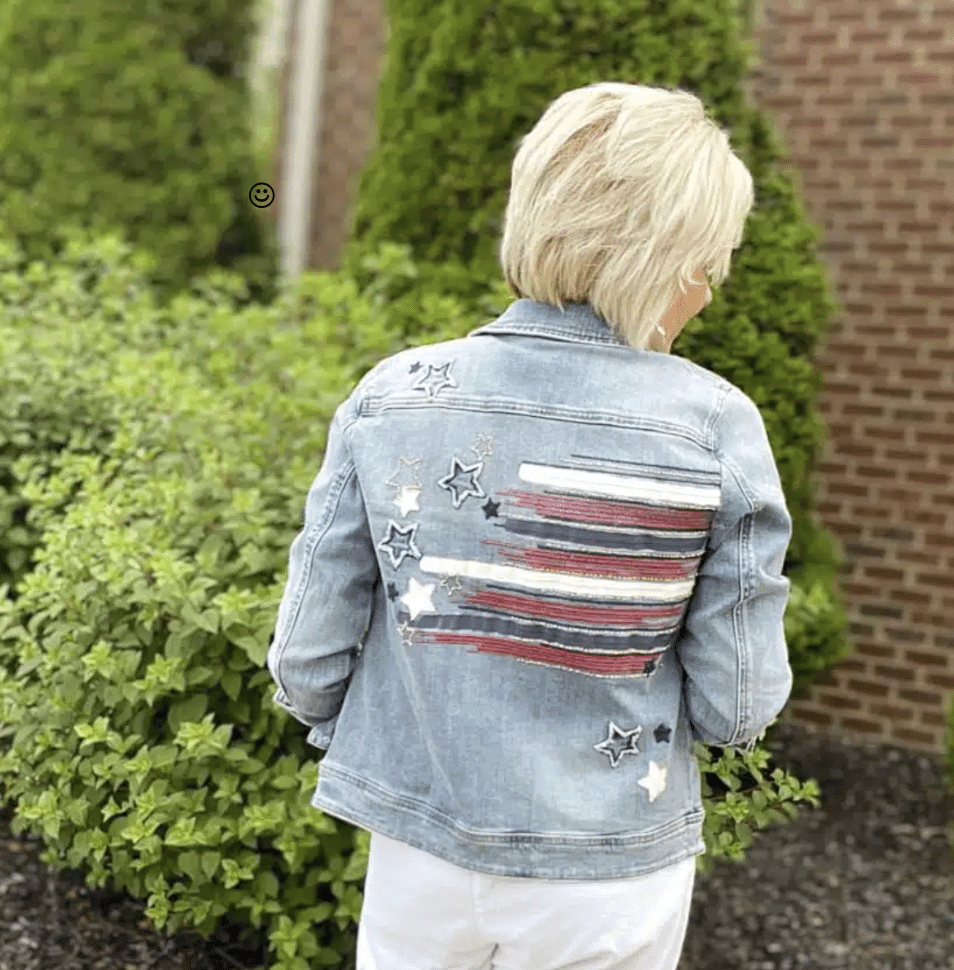 Tania showing a Chico's denim jacket with an American Flag on the back