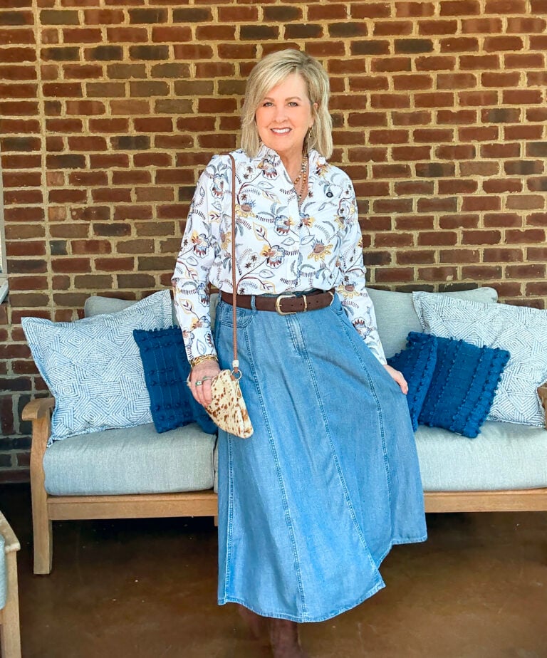 Tania Stephens showing a button up shirt with a denim skirt and boots