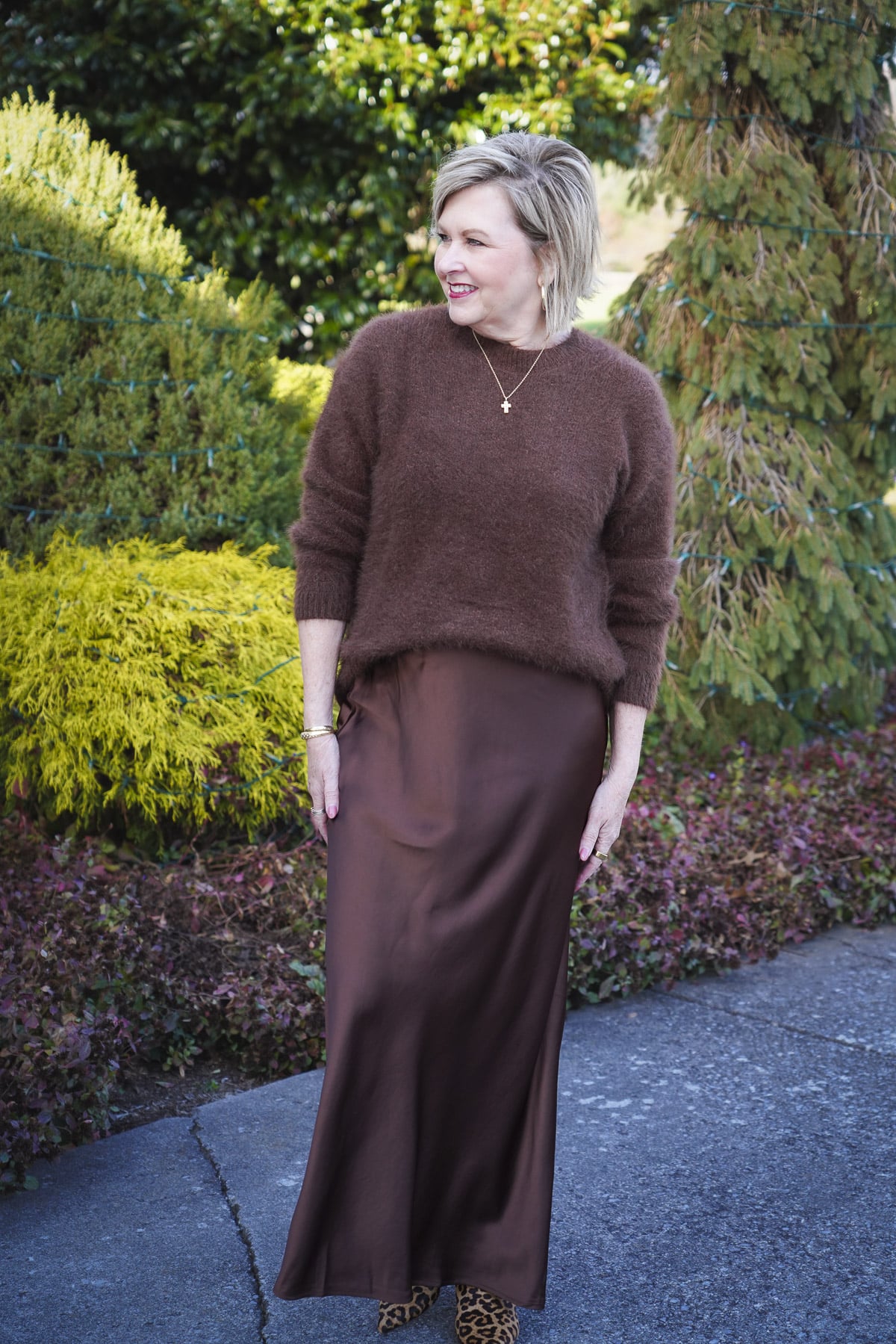 Tania Stephens is wearing a brown fuzzy sweater and satin slip