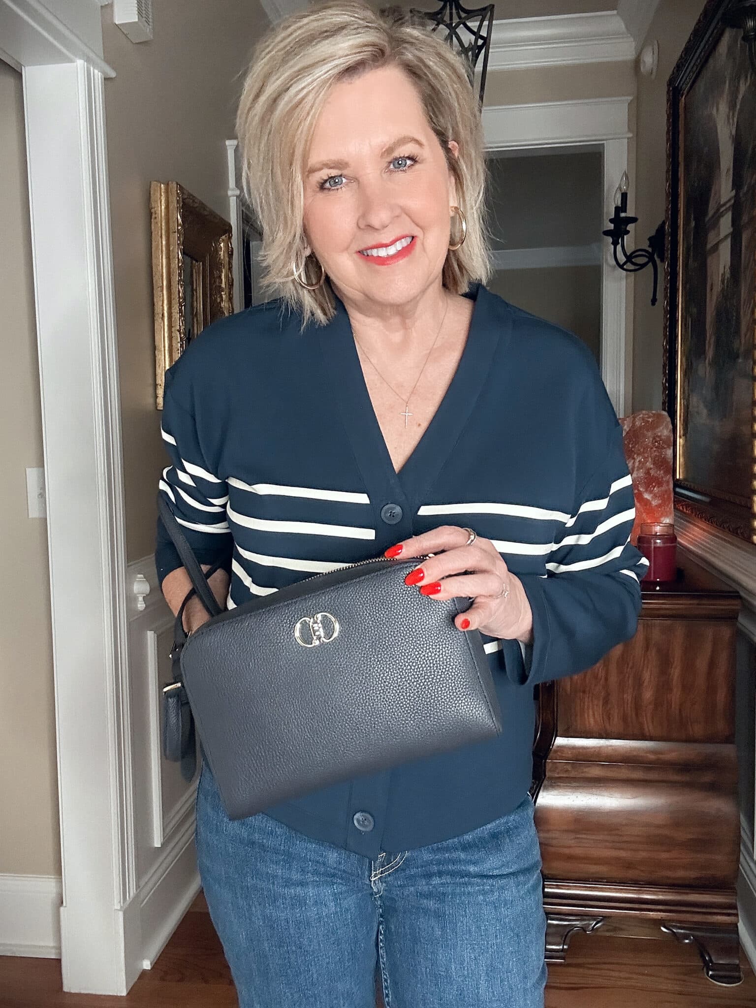 Over 50 Fashion Blogger, Tania Stephens, wearing a SPANX Air Essentials striped top and carrying a navy leather crossbody.