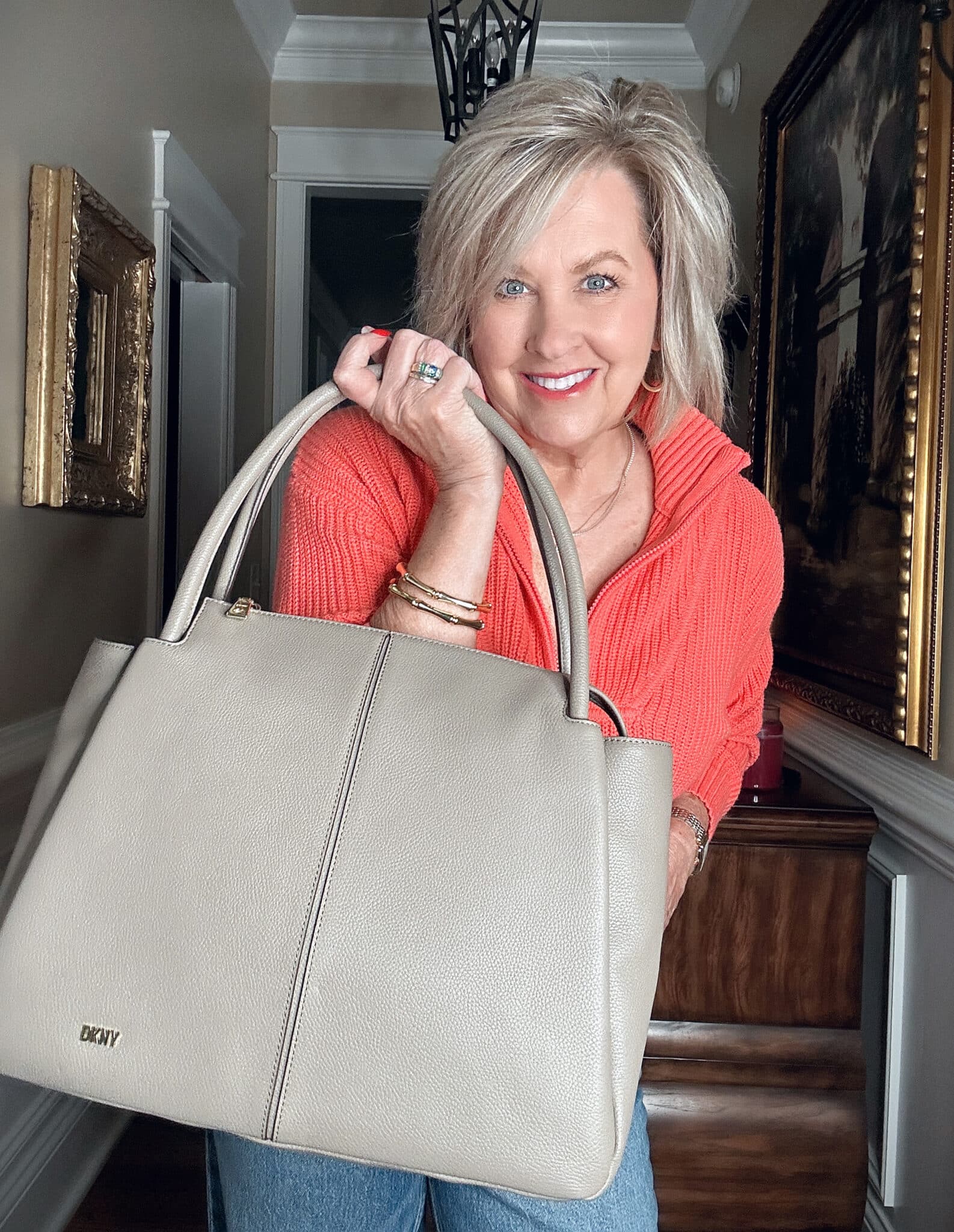 Over 50 Fashion Blogger, Tania Stephens, wearing a bright coral half zip sweater from Walmart and a taupe DKNY handbag