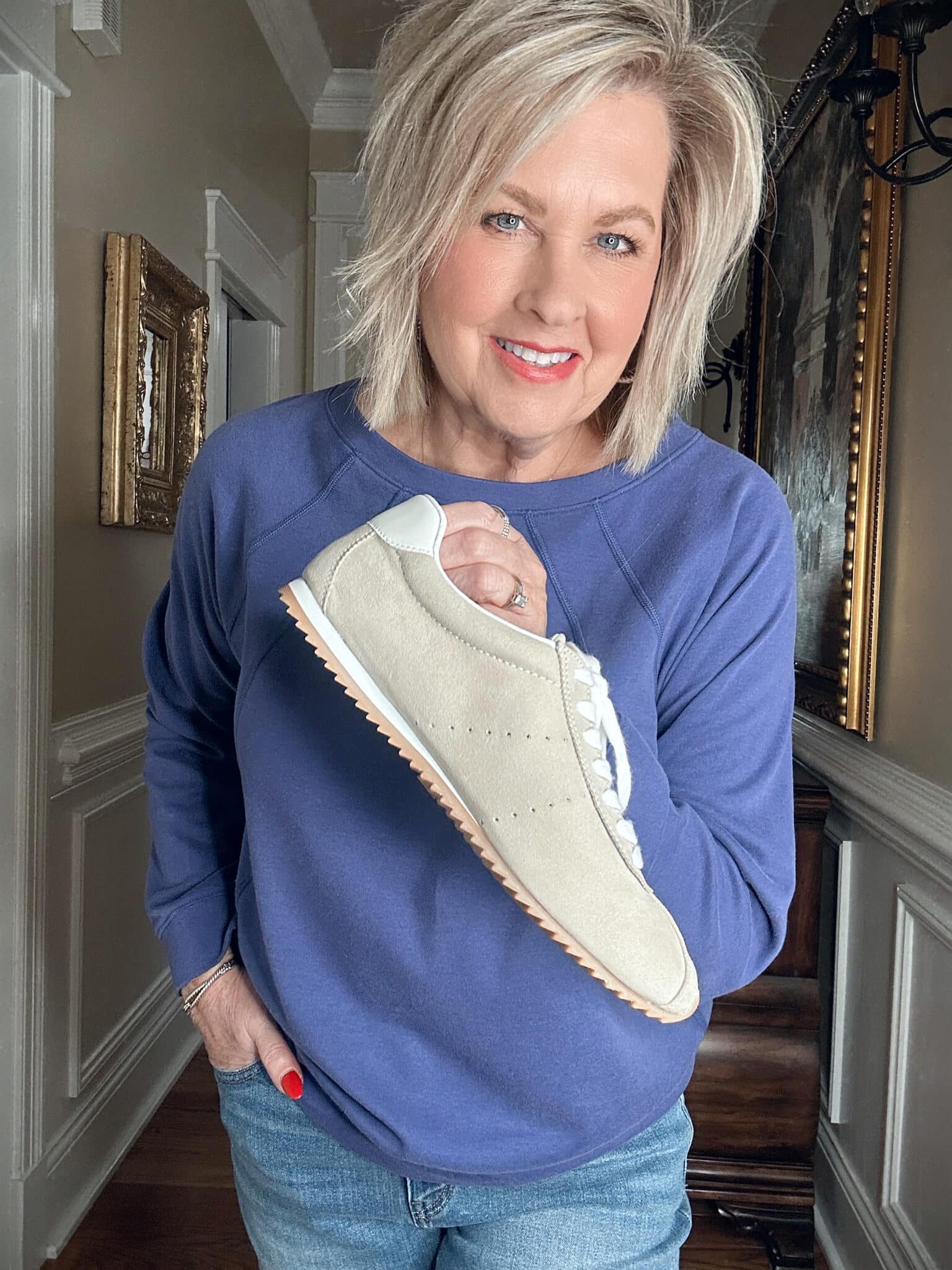 Over 50 Fashion Blogger, Tania Stephens, wearing a purple/blue sweatshirt and beige sneakers