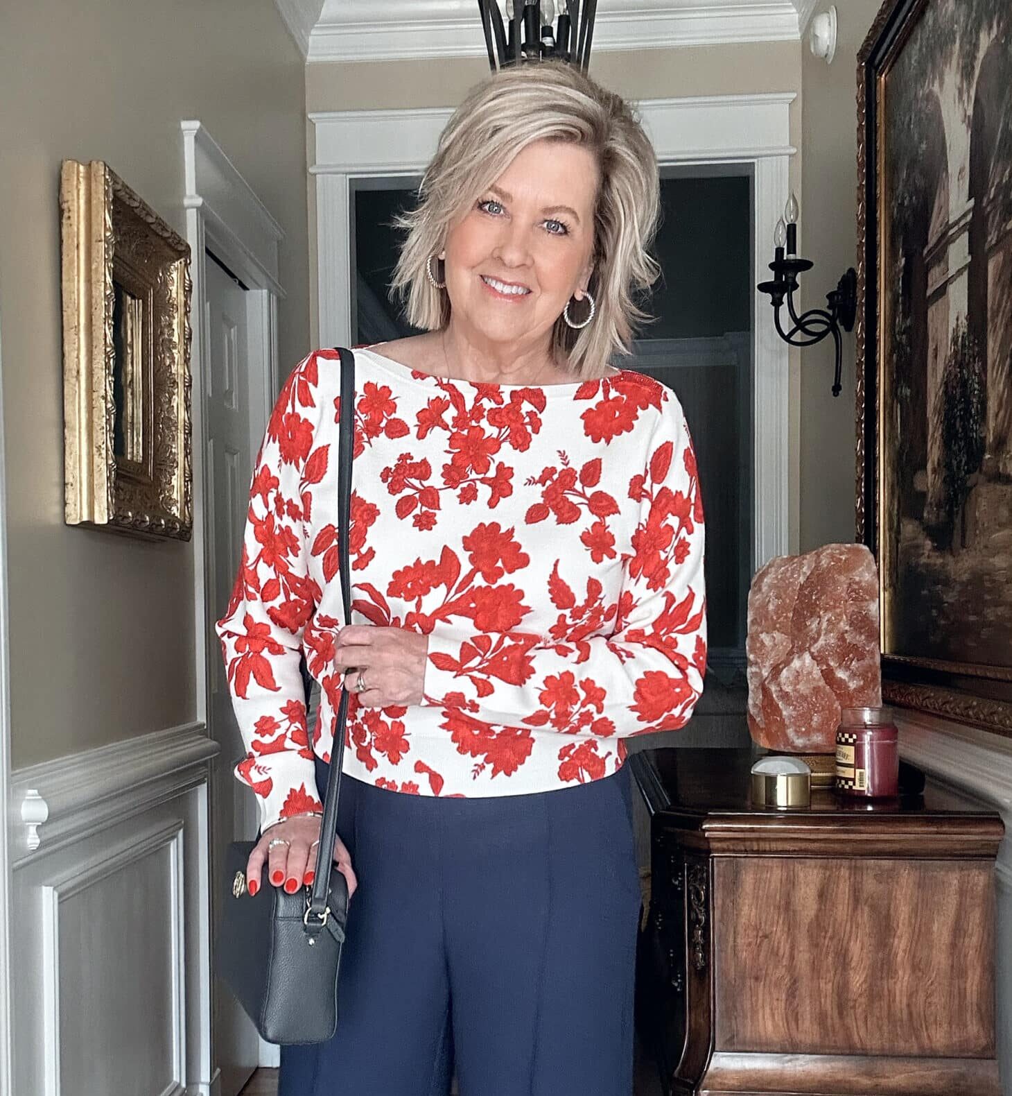 Over 50 fashion blogger, Tania Stephens is wearing a red floral sweater 
