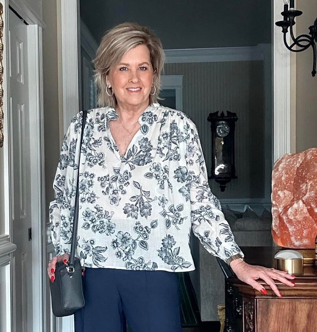 Over 50 fashion blogger, Tania Stephens is wearing a blue and white floral top 