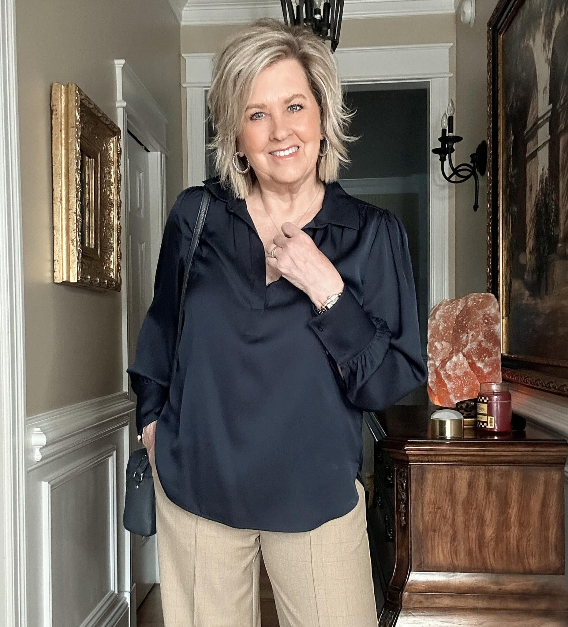 Over 50 fashion blogger, Tania Stephens is wearing a navy satin top 