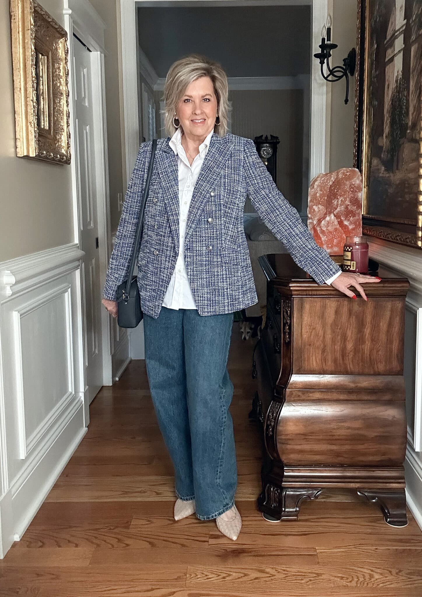 Over 50 fashion blogger, Tania Stephens is wearing a blue tweed blazer, a white button shirt, and jeans