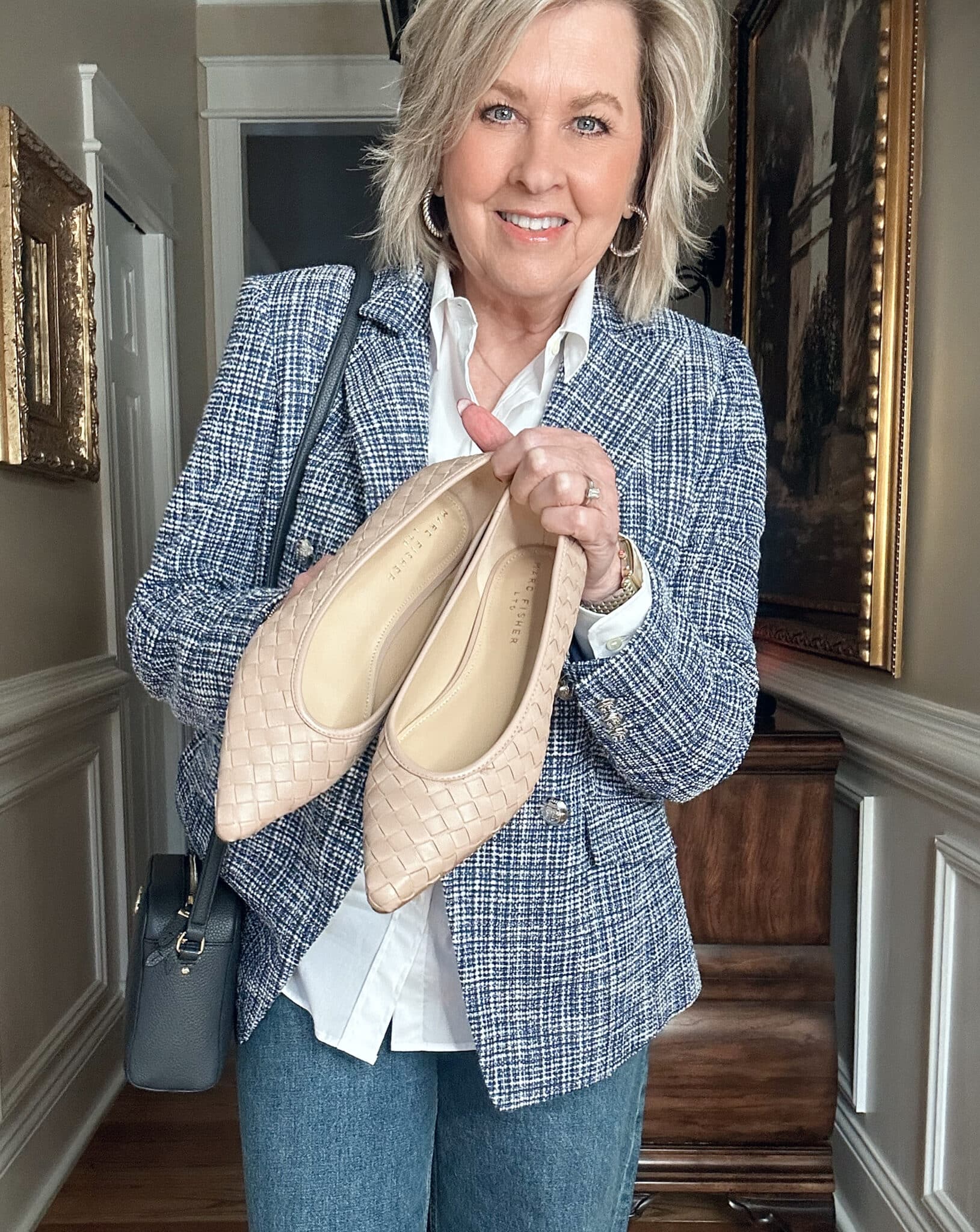 Over 50 fashion blogger, Tania Stephens is wearing a blue tweed blazer, a white button shirt, and woven shoes