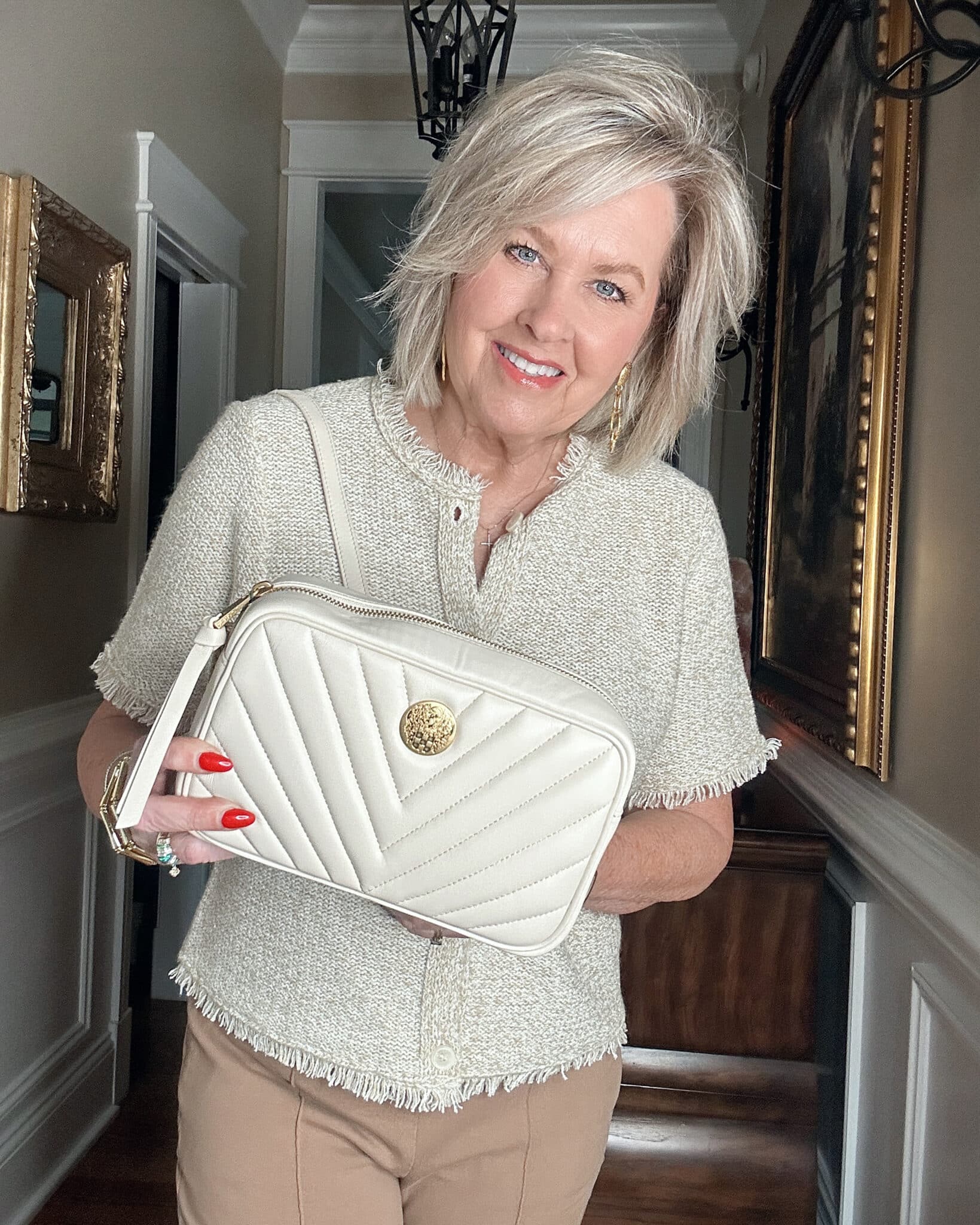 Over 50 Fashion Blogger, Tania Stephens is wearing a neutral outfit consisting of a beige fringed top with an ivory quilted crossbody