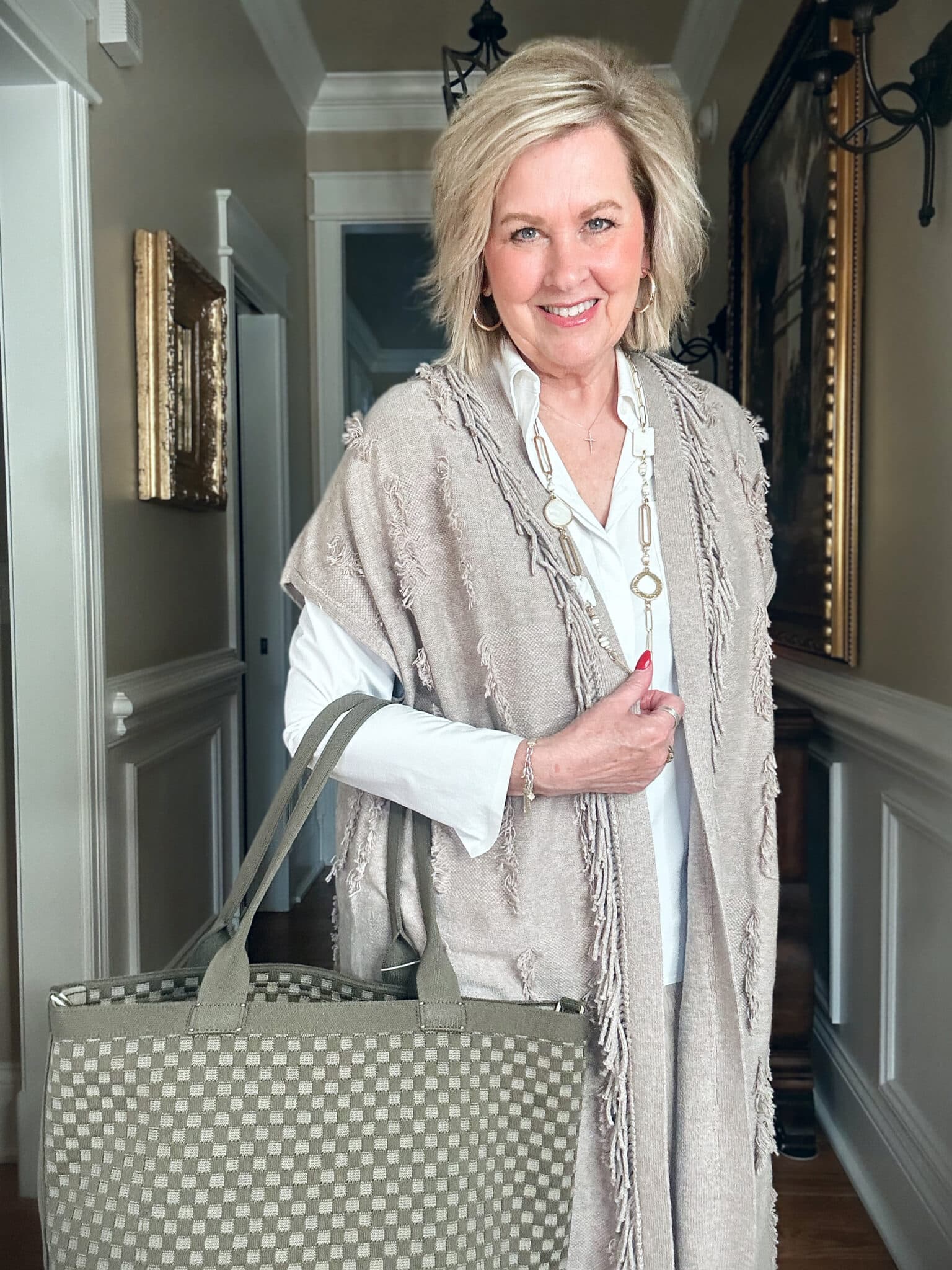 Over 50 Fashion Blogger, Tania Stephens is wearing a neutral outfit consisting of a fringed vest from J.Jill