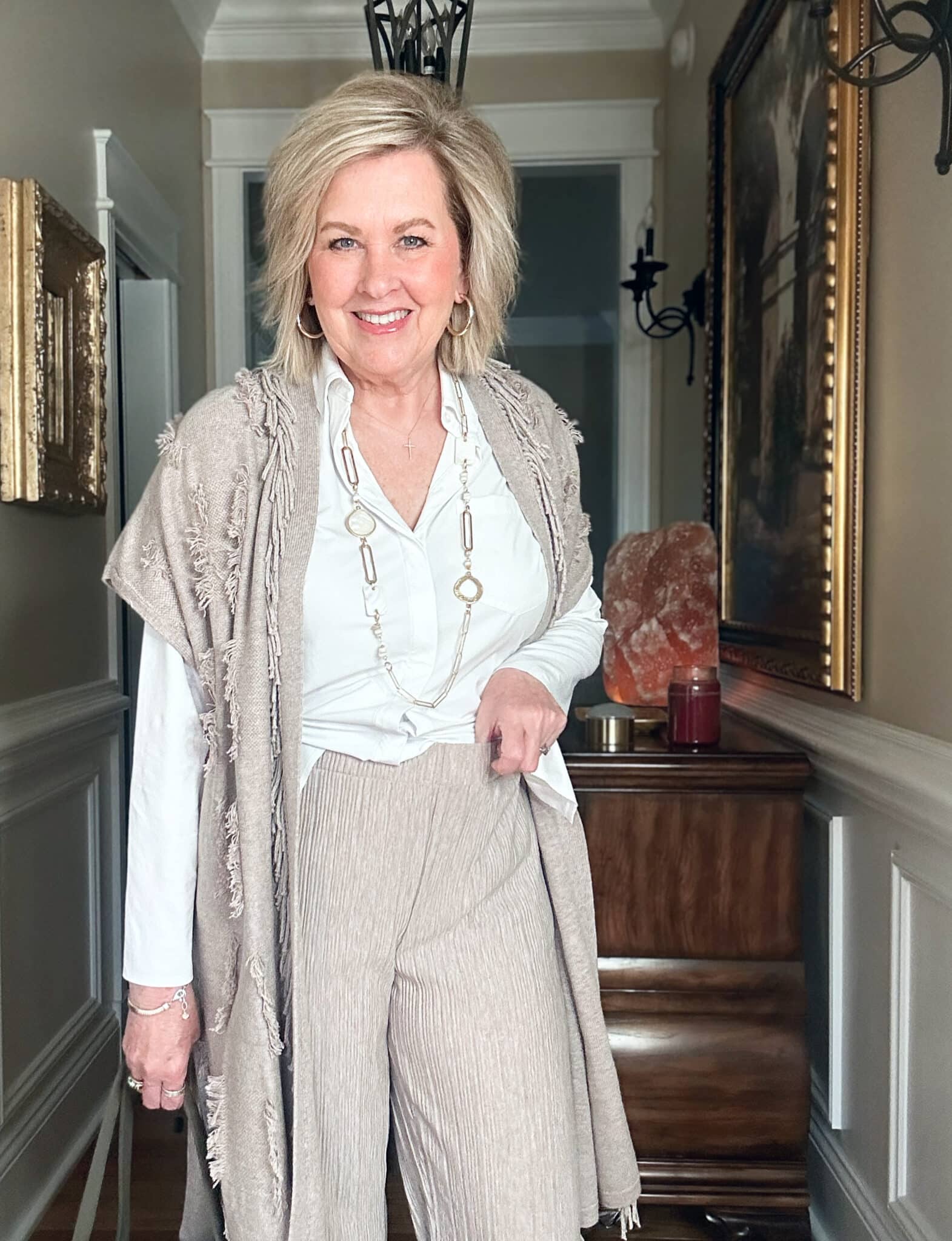 Over 50 Fashion Blogger, Tania Stephens is wearing a neutral outfit consisting of a fringed vest with beige pull-on crinkled pants from J.Jill