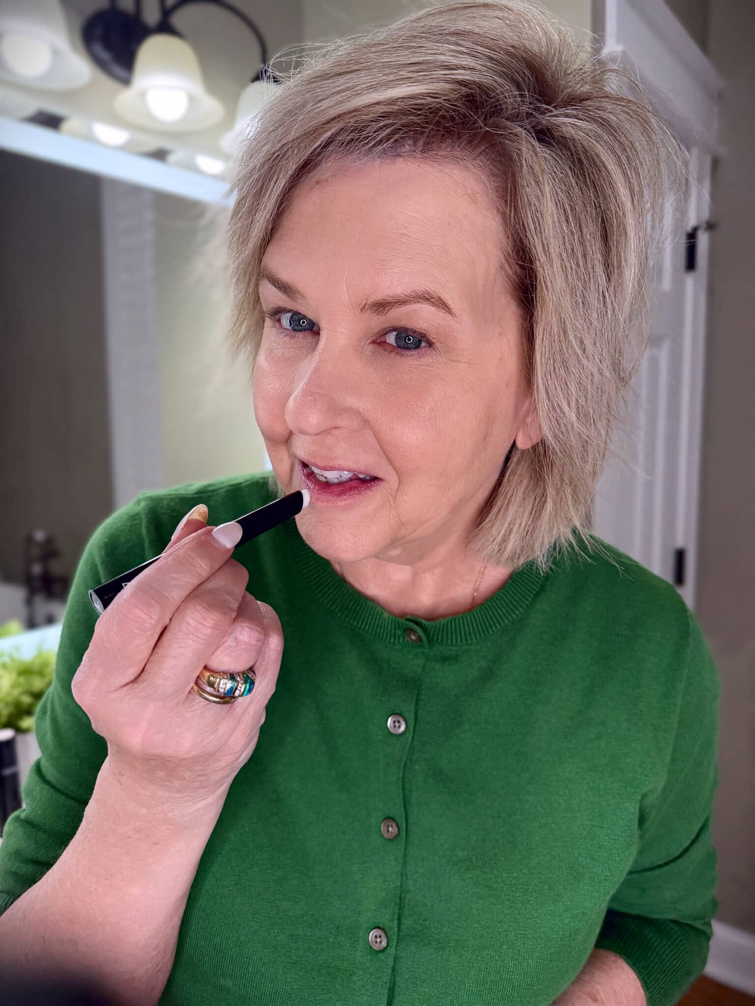 Tania Stephens in a green sweater with MAC Prime and Prep for the lips makeup from Nordstrom Beauty