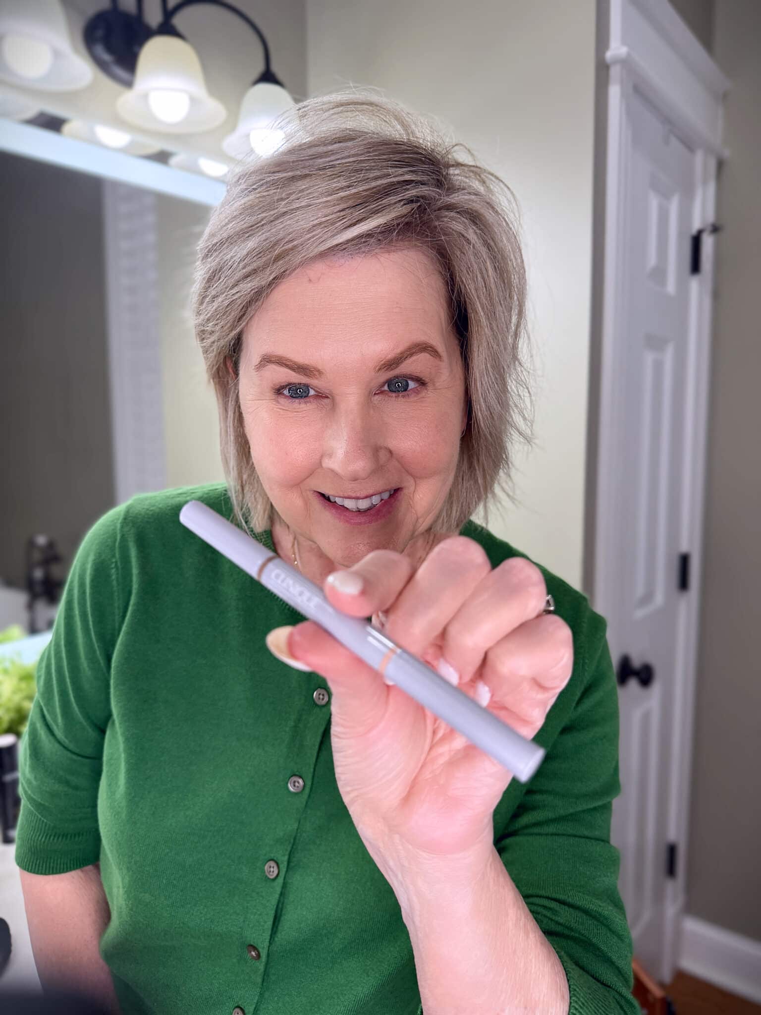 Tania Stephens in a green sweater with eyebrow makeup from Nordstrom Beauty