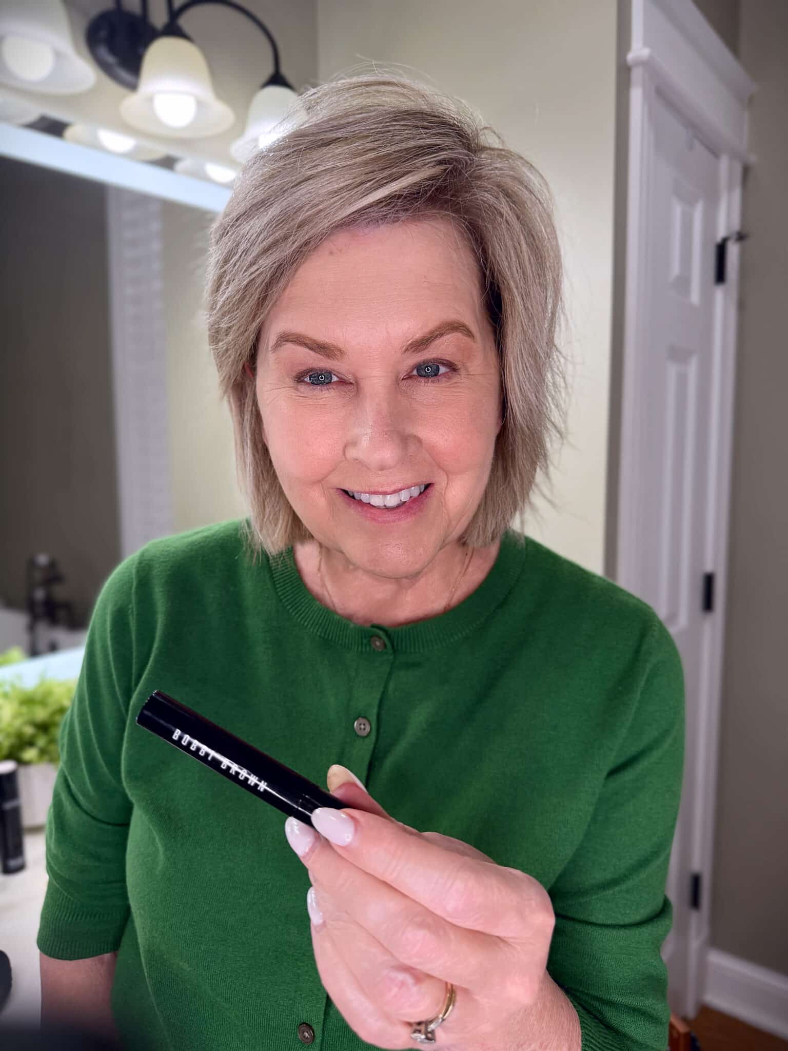 Tania Stephens in a green sweater with Bobbi Brown eyebrow makeup from Nordstrom Beauty