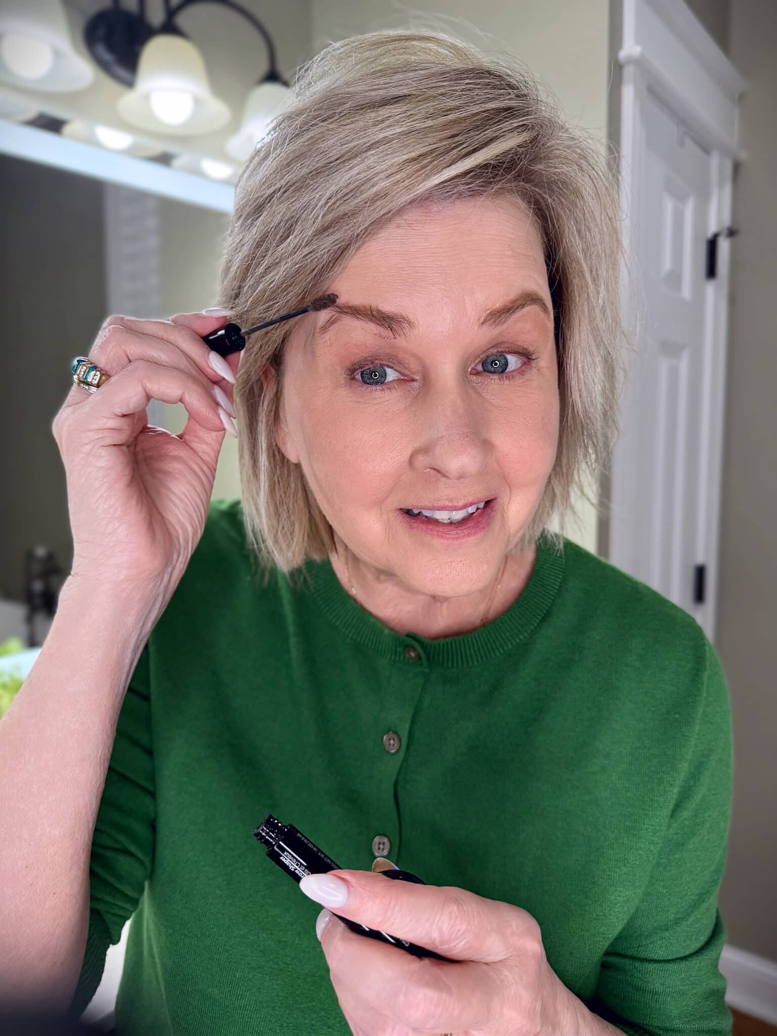 Tania Stephens in a green sweater with eyebrows filled in with makeup from Nordstrom Beauty