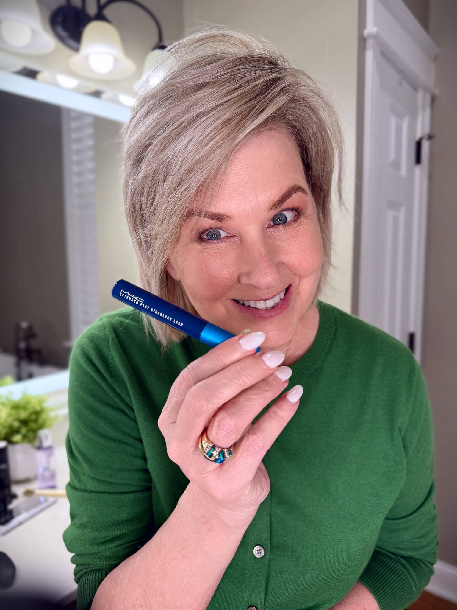 Tania Stephens in a green sweater with MAC Mascara makeup from Nordstrom Beauty